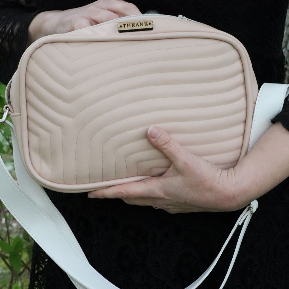 petit sac matelassé alter-cuir de raisin végan beige rosé porté dans les mains