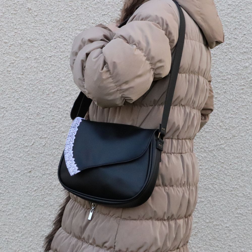 rabat cuir de raisin noir dentelle blanche sur base de sac noire porté épaule